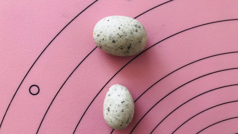 卡通小兔子馒头,把18克的灰色面团揉成椭圆形，9克面团揉成类似鸡蛋的形状。