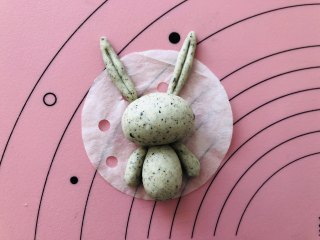 卡通小兔子馒头,把做好的耳朵跟胳膊放在馒头纸上，这样小兔子的整个轮廓就出来了。