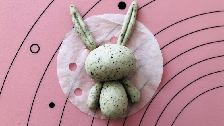 卡通小兔子馒头,把做好的耳朵跟胳膊放在馒头纸上，这样小兔子的整个轮廓就出来了。