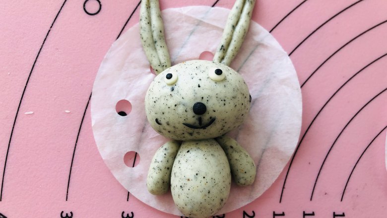 卡通小兔子馒头,把做好的五官分别贴在小兔子的脑袋上，这样一个完整的小兔子就完成了。