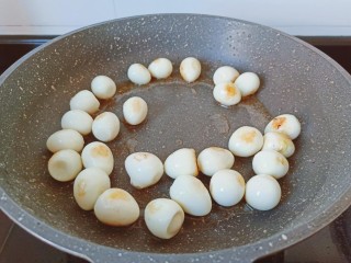 香菇鹌鹑蛋,锅里放油，把鹌鹑蛋煎一下。