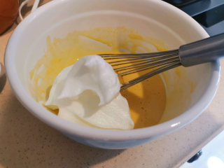 血橙蛋糕卷,取三分之一蛋白霜放入蛋黄糊中，拌匀。
