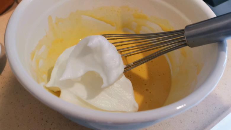 血橙蛋糕卷,取三分之一蛋白霜放入蛋黄糊中，拌匀。
