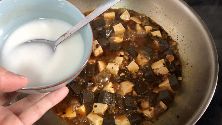猪血炖豆腐➕红白花开山雨中,加入两汤匙水淀粉，二次勾芡收汁，收汁时不时用铲子推动食材，以免粘锅