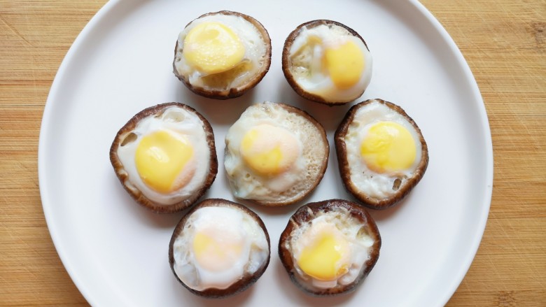 香菇鹌鹑蛋,蒸好的香菇鹌鹑蛋摆在盘子里（8朵香菇被我吃掉了一个）。