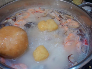 鲜虾干贝鱼片海鲜粥,倒入豆腐泡和面筋焖煮