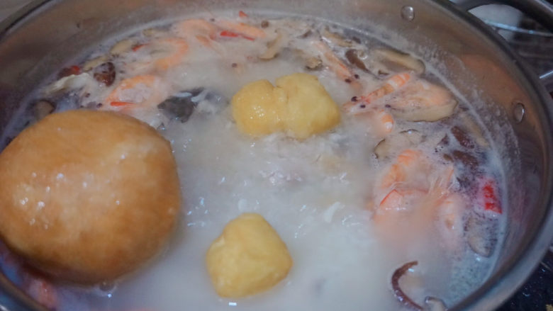 鲜虾干贝鱼片海鲜粥,倒入豆腐泡和面筋焖煮