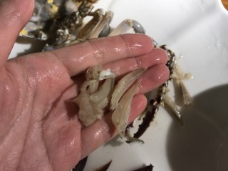 螃蟹炒年糕,去除蟹腮和小绒毛，蟹钳用刀略拍出裂纹为好