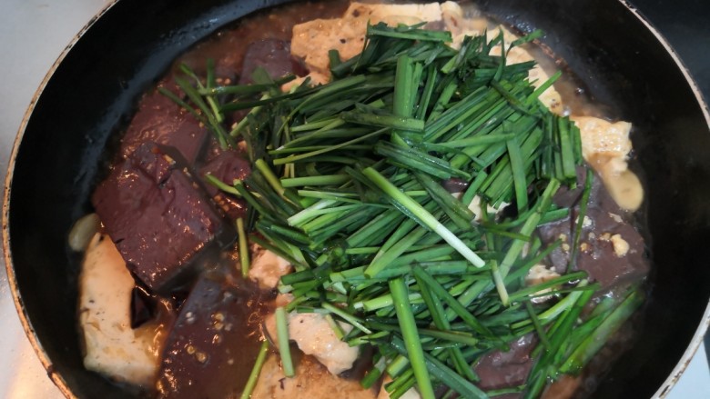 猪血炖豆腐,煮至汤汁浓稠，加入韭菜段