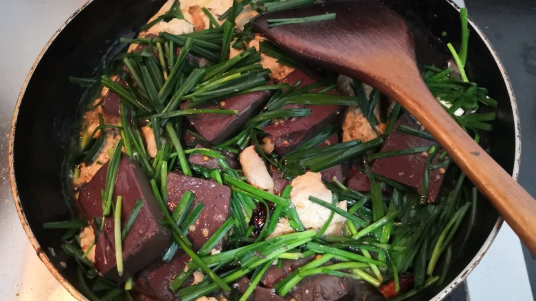 猪血炖豆腐,把韭菜段，翻拌均匀，韭菜回软，即可关火