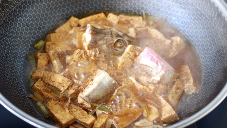 红蟹鱼酱焖冻豆腐,盖上锅盖大火烧开，继续焖煮至锅中汤汁浓稠时。