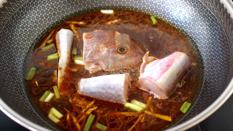 红蟹鱼酱焖冻豆腐,锅中倒入适量的清水，把切段的红蟹鱼放入。