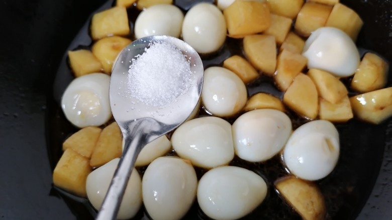鹌鹑蛋焖土豆,加入适量盐调味
