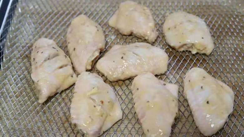 美味的法式黑椒烤鸡翅,将腌制好的鸡翅取出来，均匀的挂上一层稀面糊，放入烤箱的空气炸烤网上。生姜这时可以丢弃不要