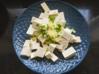 豆腐炒鸡蛋,把豆腐放入盘中。加入葱花姜末