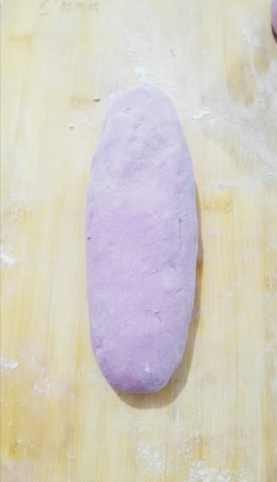 紫薯发面豆沙饼,把面团放入面板上揉匀