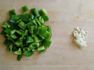 青椒炒皮蛋,青椒去蒂，去籽切小块，蒜拍扁切碎。