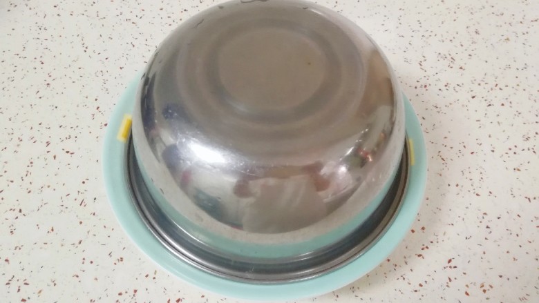 红烧鹌鹑蛋,将煮熟的鹌鹑蛋捞出用凉水泡一下，控干水分放入盘子里，上面盖一个合适大小的大碗或者盆，用手捏紧上下多次晃动。