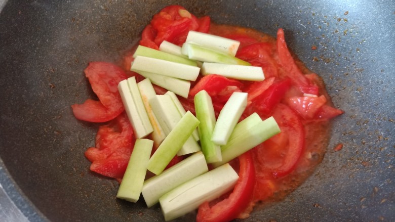 番茄炒丝瓜,在炒出汤汁后，将丝瓜到入西红柿中间。