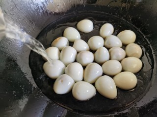 红烧鹌鹑蛋,将鹌鹑蛋倒入炒好的糖色中，然后加入水。