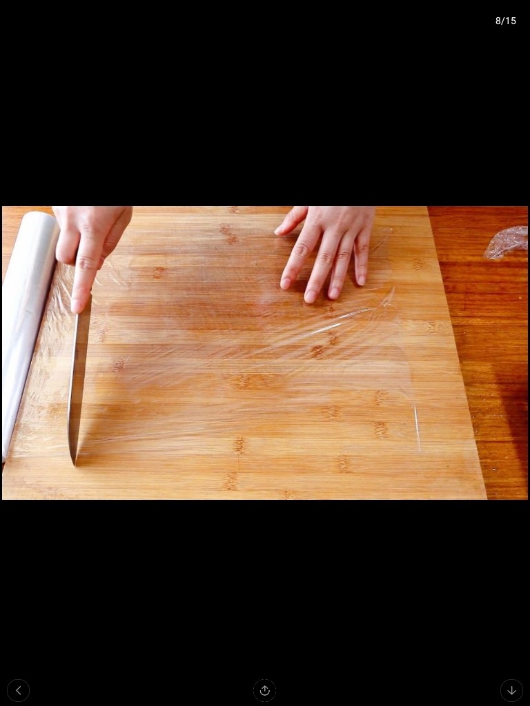 自制三明治,把保鲜膜放在菜板上切开。