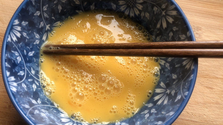 豆腐炒鸡蛋,用筷子顺时针搅拌打散。