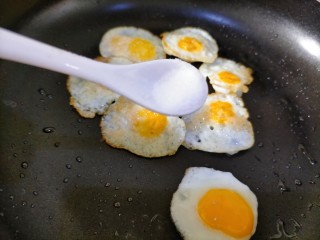 红烧鹌鹑蛋,双面煎至焦黄后加盐，轻轻撒上少许，尽量让每个蛋都粘上