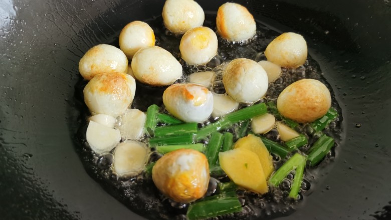 鹌鹑蛋焖土豆,加入葱、姜、蒜翻炒出香味。