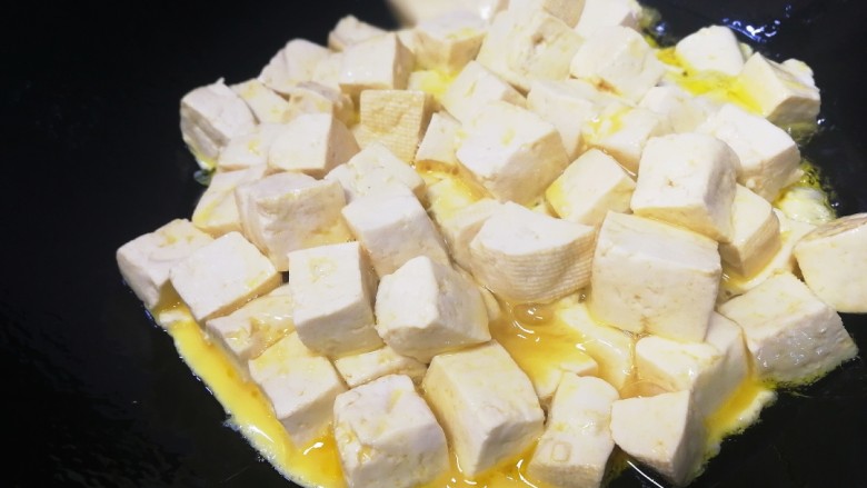 豆腐炒鸡蛋,油热倒入豆腐蛋液。