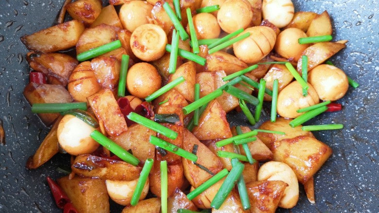 鹌鹑蛋焖土豆,下入留出来的小葱段，利用锅的余温翻炒均匀即可。