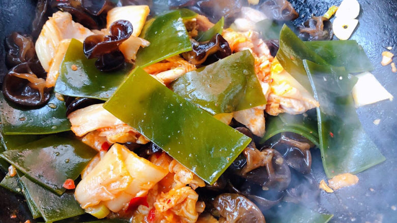 辣白菜豆腐汤,放入海带和木耳翻炒均匀