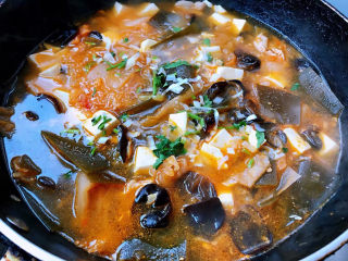 辣白菜豆腐汤,汤煮开放入盐和味精调味均匀撒上香菜提鲜即可出锅享用