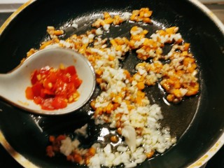 铁板日本豆腐,放入姜末 蒜碎和剁椒 翻炒出香味