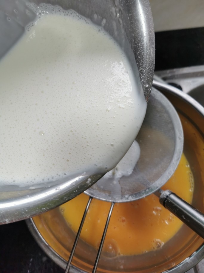 榴莲千层蛋糕,把搅拌好的牛奶过筛倒入蛋液里