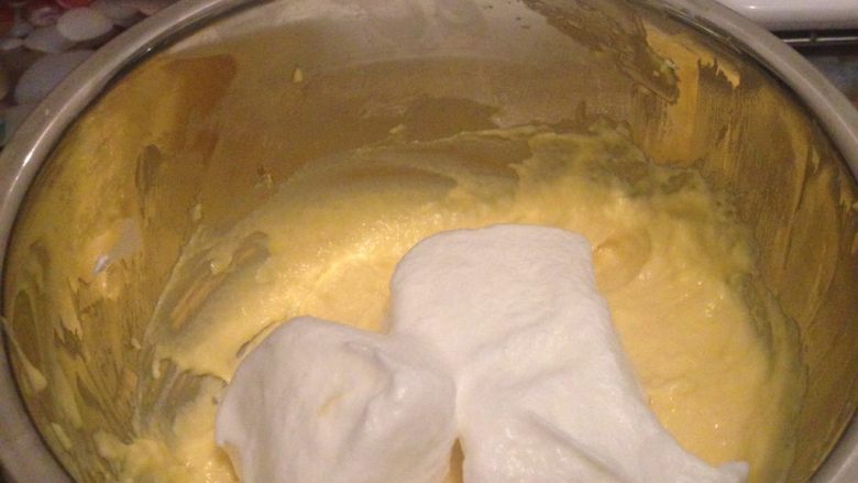 酸奶云朵戚风,分两次混合蛋黄糊与蛋白霜，先将1/3的蛋白霜加入到蛋黄糊中翻拌均匀^o^