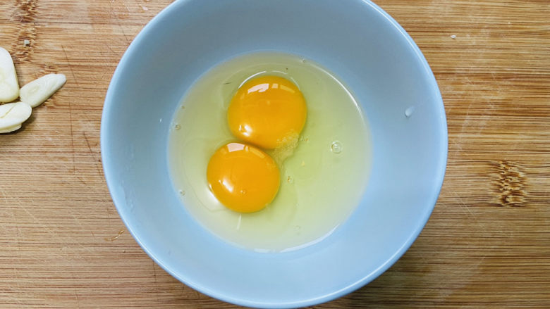 白玉菇炒鸡蛋,鸡蛋打入碗中加入少许盐
