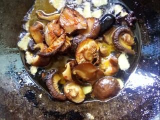 香菇焖鸡,放入香菇片小火炒香。