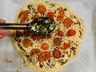 狂野番茄芝士薄底披萨,装饰的调料。