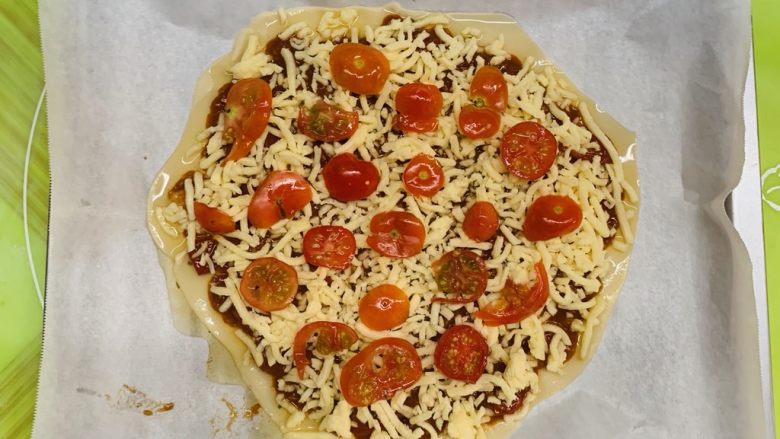 狂野番茄芝士薄底披萨,铺上装饰的番茄片。