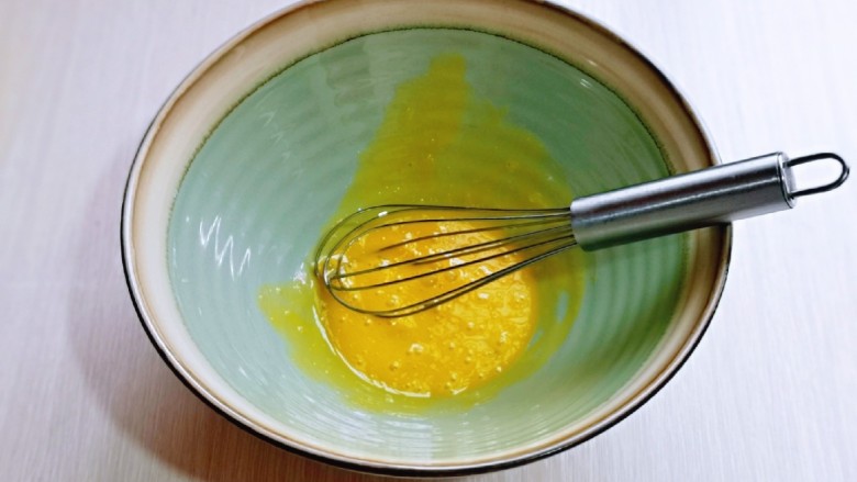 平底锅舒芙蕾,先做蛋黄糊，用手动打蛋器将蛋黄打散。
