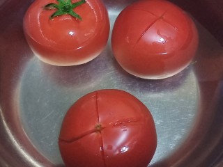 番茄肥牛金针菇,西红柿洗干净，划十字，放在开水中烫几分钟