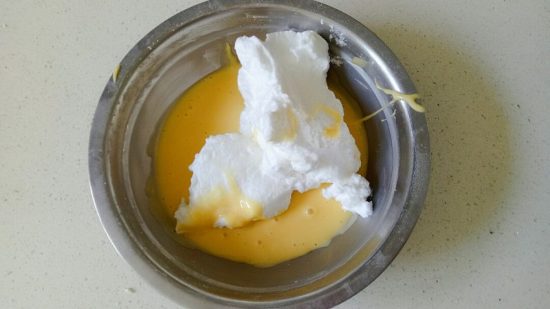 平底锅舒芙蕾,乳三分之一的蛋白加入到蛋黄糊中，用翻拌的手法，将蛋黄糊翻拌均匀