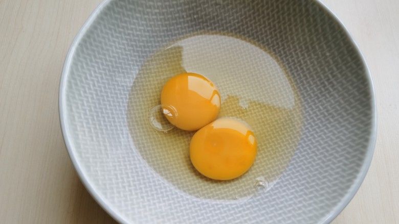白玉菇炒鸡蛋,碗里打入两颗<a style='color:red;display:inline-block;' href='/shicai/ 9'>鸡蛋</a>，用筷子搅散。