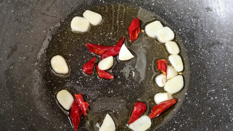 素炒白玉菇,炒锅内倒适量的食用油烧热，下入蒜片和辣椒段炒香。