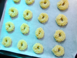 柠檬曲奇饼干,花嘴垂直于烤盘，均匀绕圈挤出；