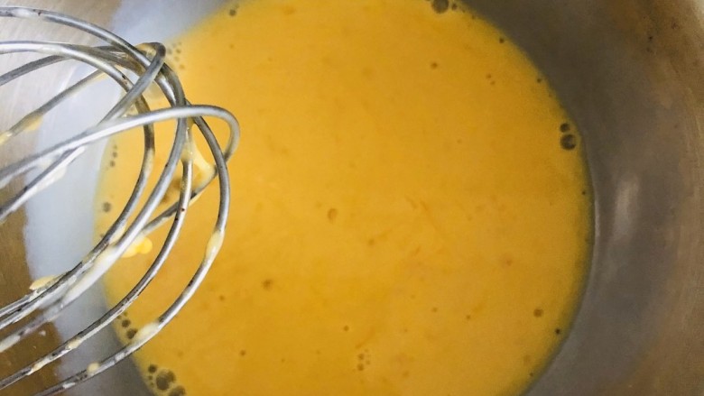 平底锅舒芙蕾,蛋黄中加入30克牛奶，手动打蛋器搅散