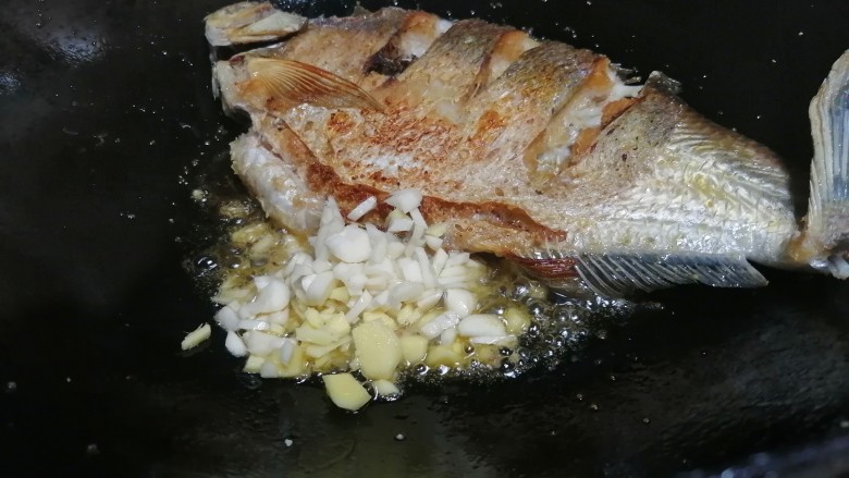 红烧鳊鱼,鳊鱼两边煎金黄后倒入姜蒜炒香