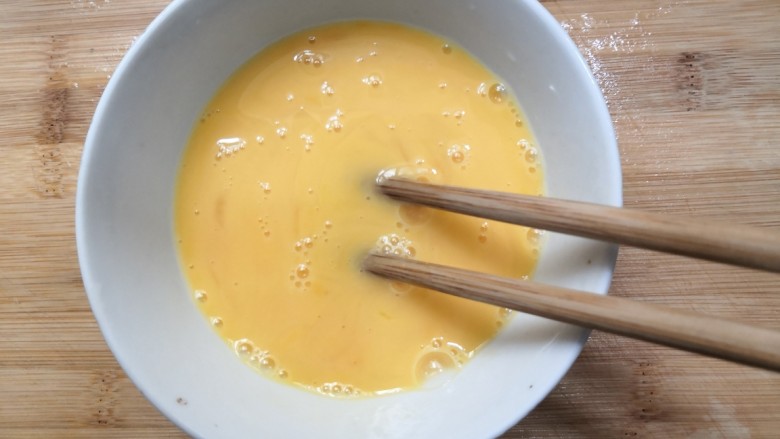 白玉菇炒鸡蛋,用筷子，把鸡蛋搅拌均匀，备用