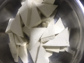 家常烧豆腐,把豆腐先切成厚片，再斜着切一刀，切成三角形，装入容器内备用