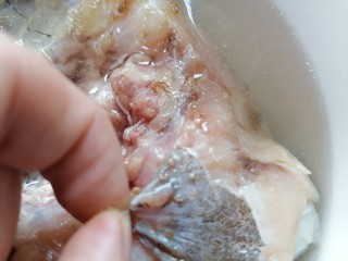 豆腐鱼头汤,将鱼头鱼肉上的黑色筋膜撕掉并清洗干净